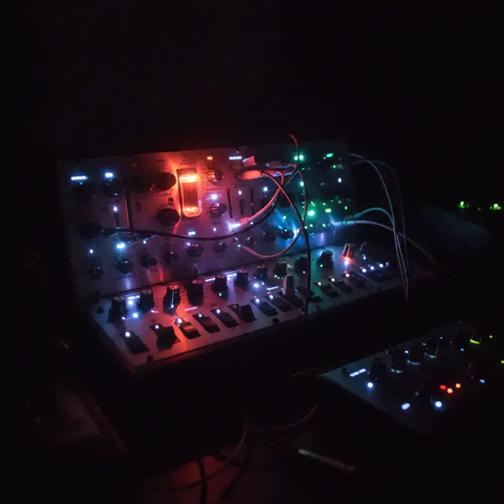 Analog synthesizer hardware glowing in the dark
